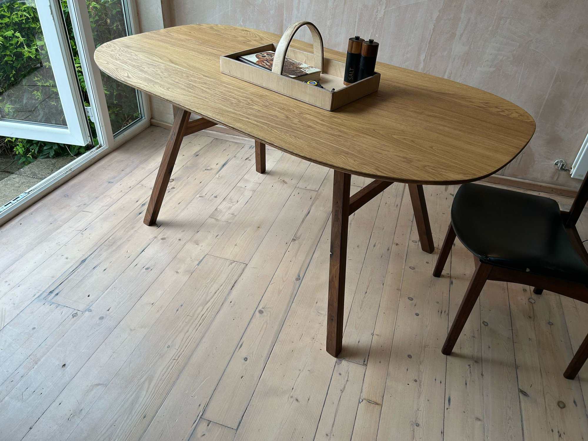 Natural oak dining table with tapered legs, contemporary design by Alex Murphy Furniture.